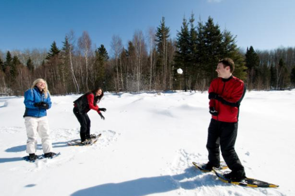 Three people out for a snowshoe stopping to have a snowball fight