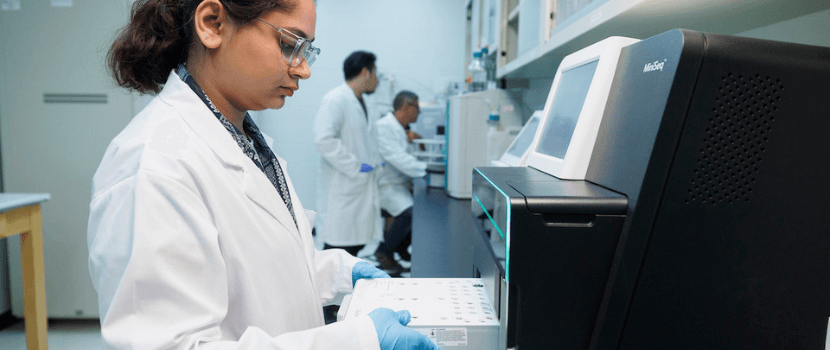 Person pulling out the bottom drawer of a MiniSeq