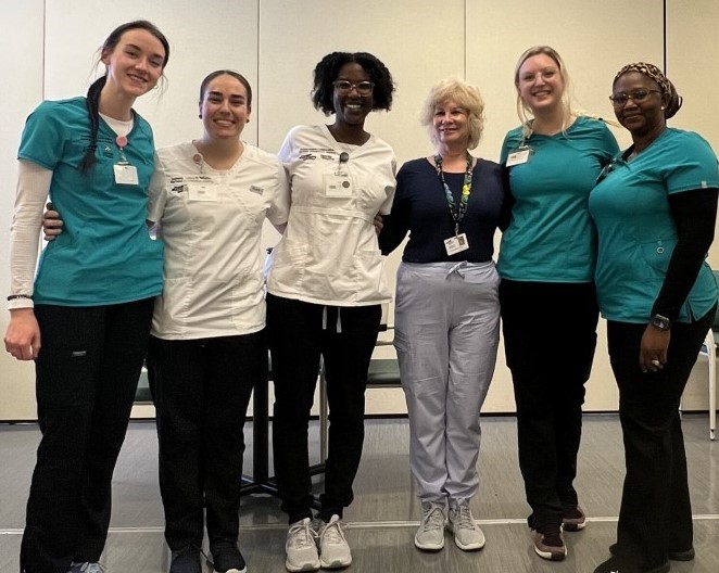 Six individuals from nursing clinical group standing in a line