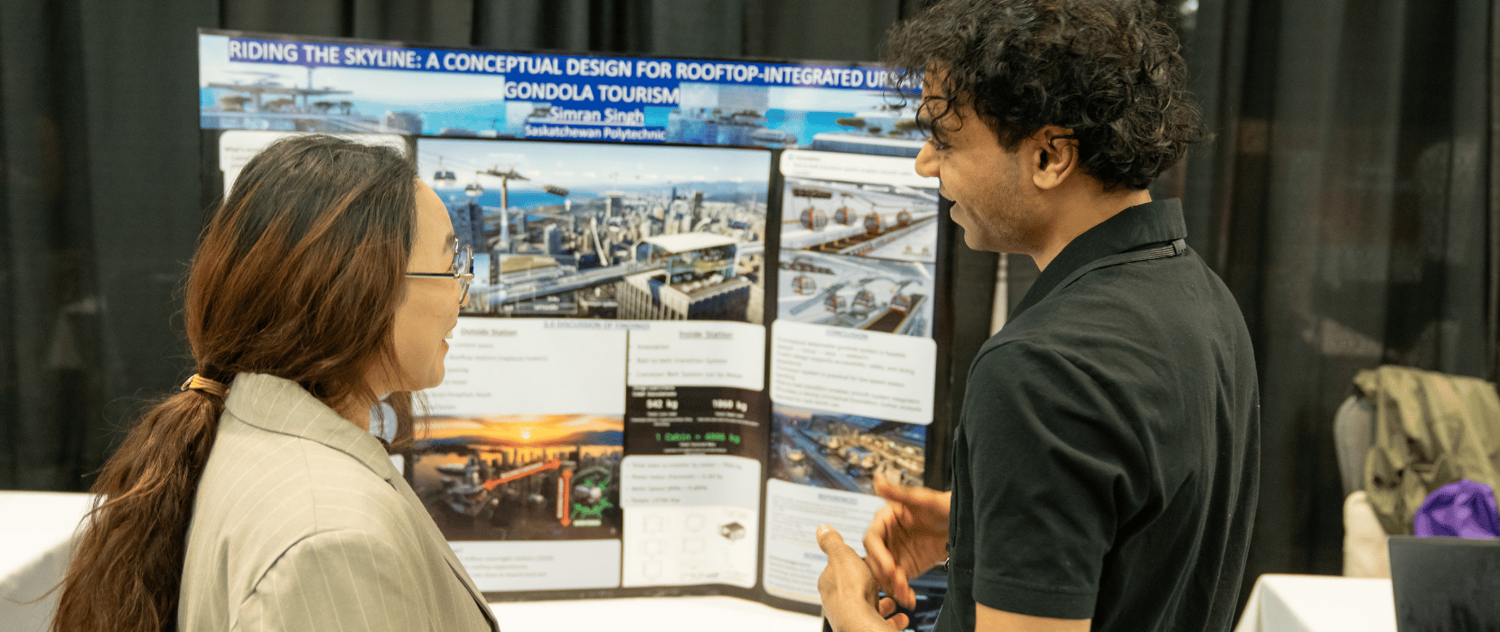 Showcase event 2026 - Two people discussing a presentation board titled 