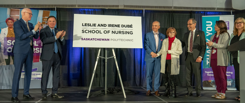 Irene Dube and family in front of the Leslie and Irene Dubé School of Nursing sign