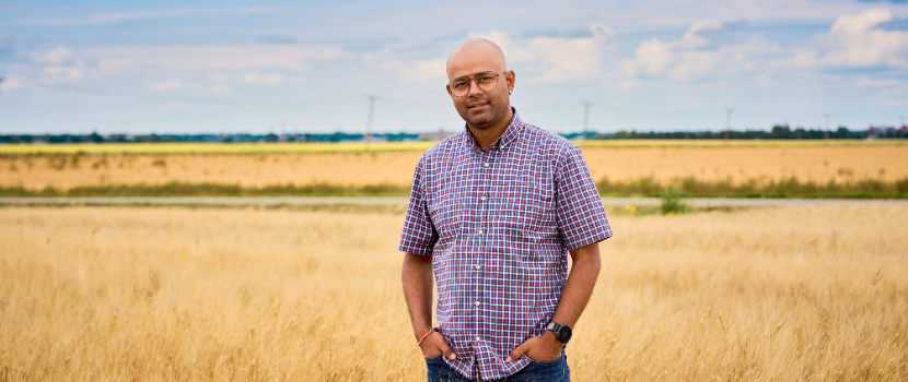 Dr. Rajeev Dhakal standing in a wheat field