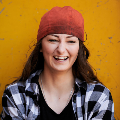 Person standing in front of yellow wall smiling and laughing